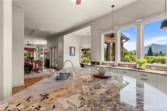 Open kitchen with a statement island and abundant counter space, designed to take in natural light and picturesque orchard and mountain views.