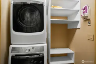 Conveniently located between the primary and guest rooms, this laundry closet features a Maytag washer and dryer along with additional storage space for everyday ease.