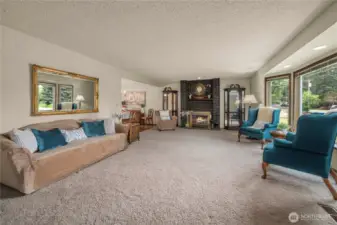 Living Room view from Entryway. Working fireplace, neutral flooring, and glorious bay window seating that spills all that natural light into this home