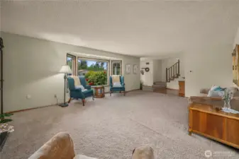 View of living room, entry, and stairs from dining room