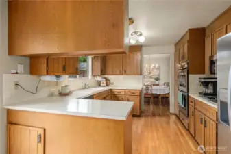 View of kitchen and dining room from kitchen eating space. You shaped kitchen has space for a table seating area that opens up to the expansive outdoor space