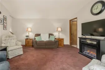 Family room with steps to the kitchen on the left and access to half bath, laundry room, and garage to the right