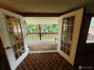 Double French doors open to Living room of this home from covered porch.