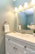 Wider angle pic of half bath with updated vanity, lighting and paint.