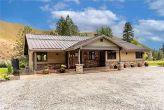 A beautifully designed exterior showcases timeless curb appeal with stone accents, a welcoming covered entry, and manicured flower beds. This home blends mountain charm with modern style in a picture-perfect setting.