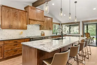This stunning kitchen offers an open-concept design with custom wood cabinetry, quartzite countertops, and premium stainless steel appliances, creating both beauty and functionality.