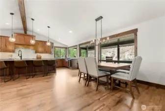 An open-concept dining area seamlessly connects to the gourmet kitchen, complete with wood cabinetry, quartz countertops, and pendant lighting. Perfect for entertaining, the space accommodates both casual and formal gatherings.