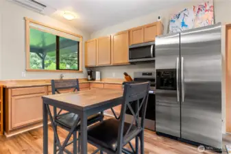 The guest house kitchen is both practical and inviting, with abundant cabinetry, modern appliances, and a dining nook. A window over the sink provides peaceful views of the outdoors.