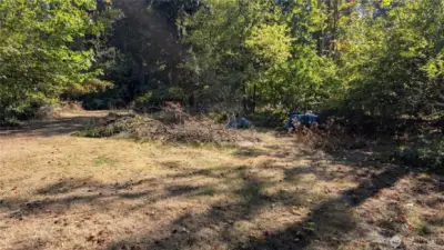 Flat with large cleared areas and mature trees with undergrowth.