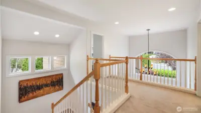 Enjoy this light-filled upper landing overlooking the grand entry, accented by elegant railings and architectural charm.