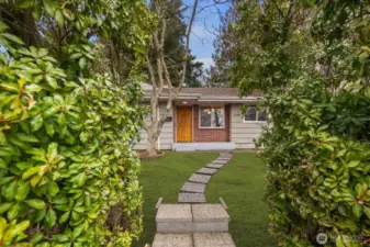 View of the home from the sidewalk. Pavers leading up to the front entrance.