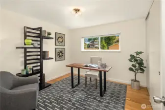 Currently staged as an office, the first bedroom offers oak hardwoods.