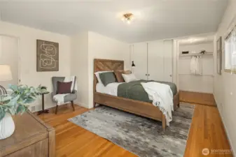 Spacious primary suite with hardwood floors, walk-in closet & built-in wardrobe storage.