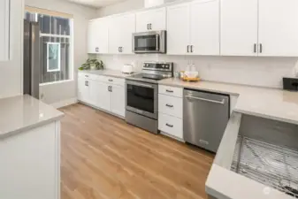 Gorgeous kitchen features slab counters, soft close cabinetry and upgraded SS appliance package.