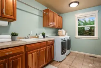 The spacious laundry room is conveniently  located upstairs with built in ironing board  and utility sink.