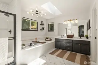 The expansive primary bathroom includes a separate shower, soaking tub, double vanity, toilet room and skylight.