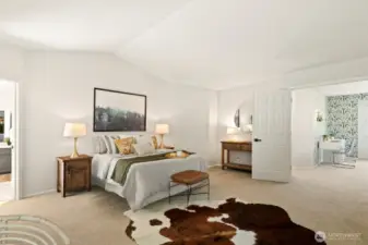 Vaulted ceilings and double doors into the primary bedroom aid in making this room feel grand.