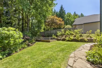 The fully landscaped back yard provides a spot to garden, plus open grass to spread out or enjoy lawn games.