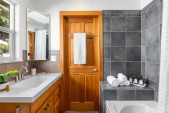 The main floor jack-and-jill bathroom features heated tile floors. Soaking tub with shower and a skylight.
