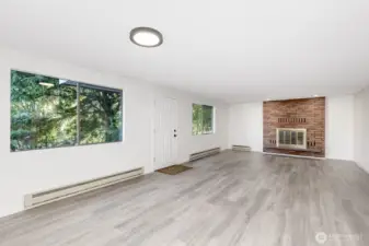 View of living area reflecting beautiful brick heat-o-lator fireplace and all new flooring throughout.