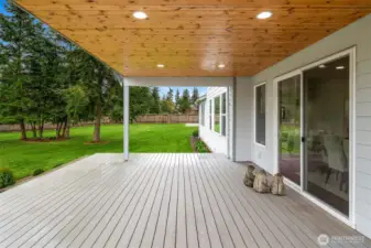 A covered back deck looks over the back yard