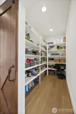Large walk-in pantry behind this gorgeous wood barn door.
