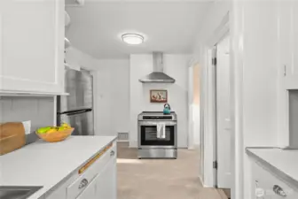 Fresh and functional details keep things easy here, with a one year new stove and hood and one year new LVP flooring underfoot. The door to the right leads straight out to the backyard and down to the basement, making everyday flow feel simple and intuitive.