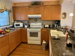 The kitchen boasts tile, marble counters and laminate wood flooring.