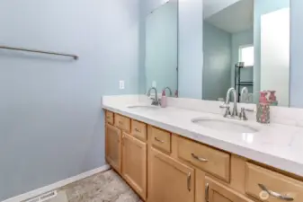 Double vanity with quartz counters in hall bath.