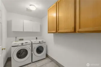 Brand new washer dryer in laundry and pantry room on the main floor with tiled floor matching kitchen floor