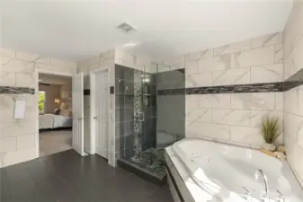 Master bathroom with a tiled standing shower, jacuzzi tub, extra cabinetry, wall to wall tiles