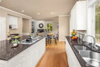 A pantry on the left, a built-in desk to collect mail and keep the counters tidy, and opening straight to the family room as well as the vast deck.