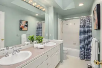Upstairs full bathroom, with skylight, dual sinks, and shower/tub.