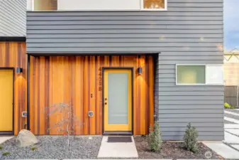 Vertical cedar siding defines the exterior with warmth and texture, setting the architectural tone.