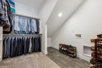 Effortless organization: Enjoy ample room for an extensive wardrobe, additional storage, and a private washer/dryer  in this expansive walk-in closet.