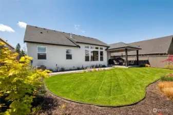 The beautiful, fully fenced backyard offers plenty of space for play, pets, or parties.