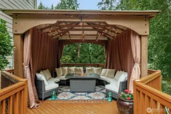 Enjoy the beautiful nature surrounding you year-round in this outdoor living space in the covered gazebo with a fire table. This deck also features additional support and is wired for a hot tub.