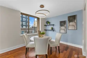 Chic dining space with modern lighting, accent wall, and city outlooks—perfect for entertaining.