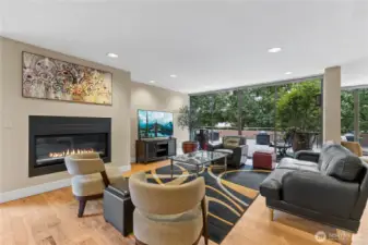 Stylish community lounge featuring a cozy fireplace and TV, perfect for relaxing or entertaining.