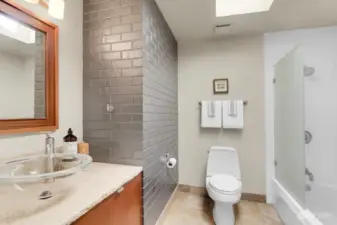 Filled with delightful details, the main floor full bath features radiant tile flooring, custom vanity of African Ribbon Mahogany with under-cabinet lighting, real stone counter, designer glass vessel sink, re-glazed tub, custom glass shower wall and new lighting. Your guests will love this!