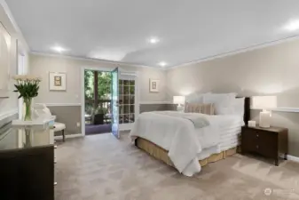This king-sized, primary bedroom suite offers 2 closets, crown molding and French doors to a private covered deck overlooking the lush backyard.