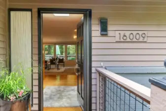 You have arrived at the front door over a newly refurbished deck and will enter on sustainable bamboo flooring in this spacious entry.
