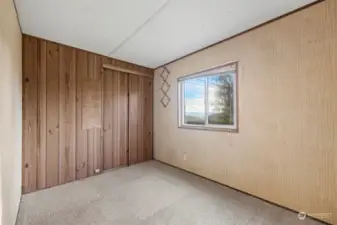 Another view of this bedroom with the paneled wall that has the clothes closet.