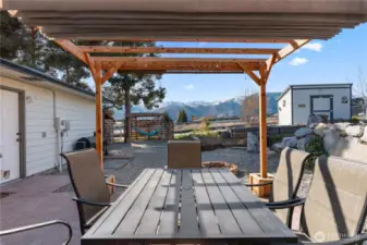 This arbor over the dining table has a sliding roof cover and a pull down shade on the west end to set the stage for comfortable outdoor dining no matter the weather.