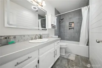 Full bath downstairs w/new tub, tile surround, toilet, flooring & counters