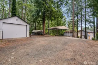Ample room for vehicles, gear, and more with a garage, carport, original shed, and well house.