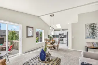 Open-concept living continues into the dining space and kitchen. Vaulted ceilings, broad windows, and deck access create an airy gathering zone that suits both casual meals and larger occasions.