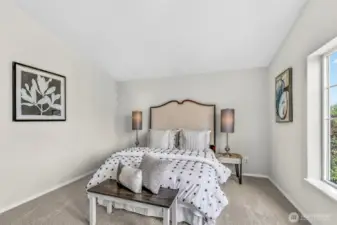 Primary suite retreat with vaulted ceiling, fresh interior paint, and new carpet underfoot. The wide window frames leafy neighborhood views and the generous wall space supports multiple layout options.