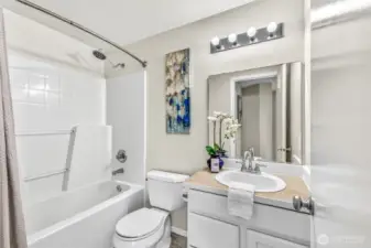 Upper-level full bath with a curved shower rod, and bright lighting. Neutral finishes make it easy to personalize while maintaining a fresh, move-in-ready feel.