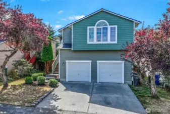 Inviting Bothell façade framed by mature landscaping and an arched upper window. Fresh exterior paint and a 2023 roof complement the two-car garage and wide driveway, offering easy parking on a low-maintenance 3,200 SF lot in the Everett School District.